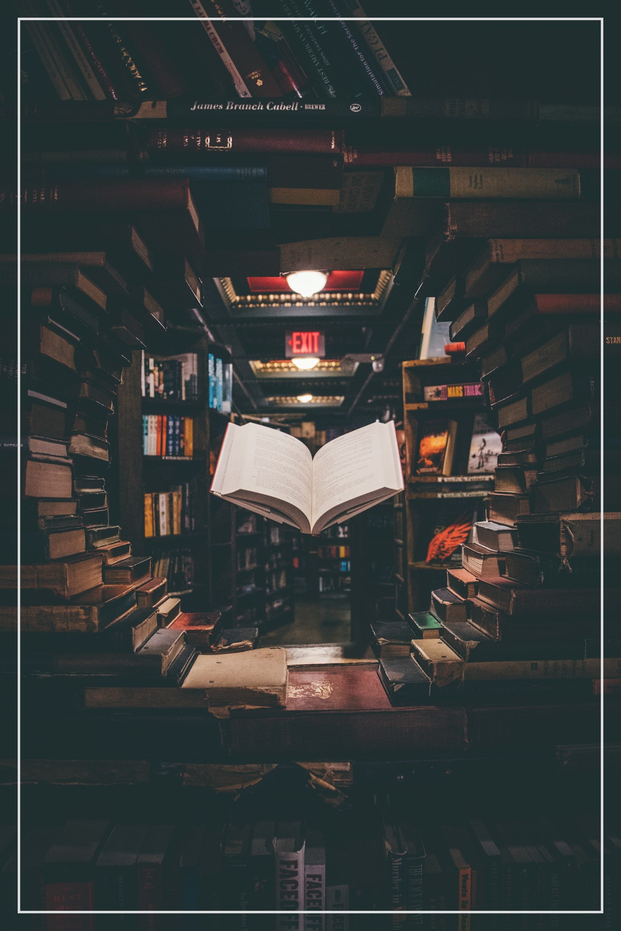 view of floating open book from stacked books in library